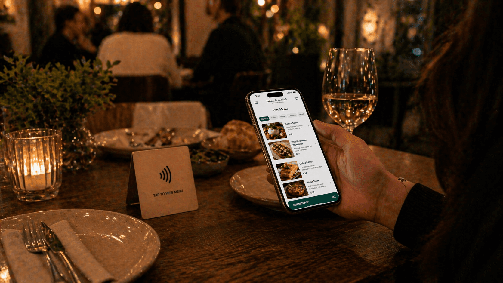A modern restaurant table with an NFC card visible and a guest using their phone to view the menu